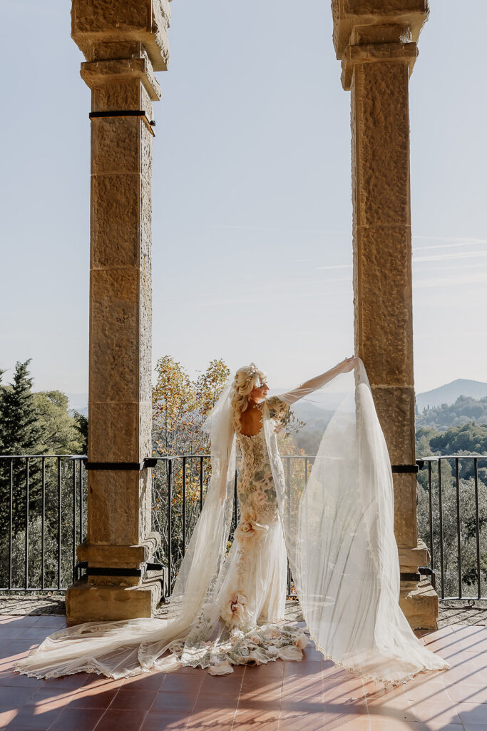 Bride holding her veil with mountain views behind her at the La Baronia wedding venue in Barcelona Spain.