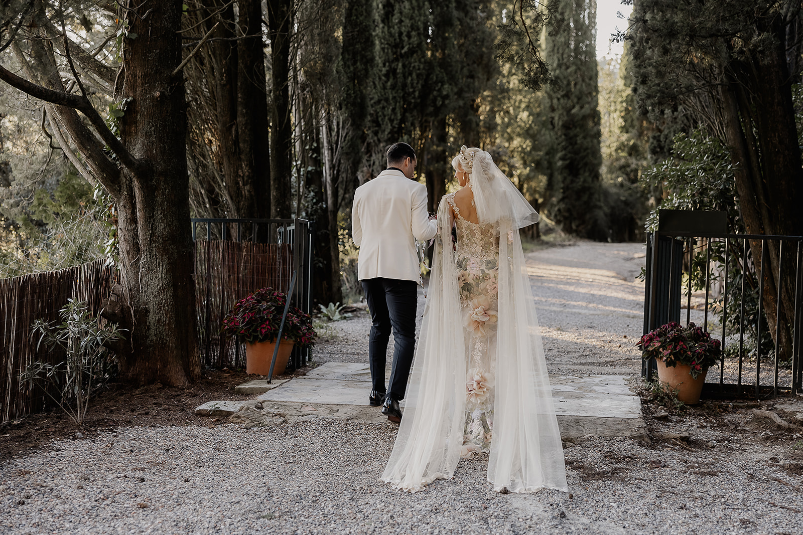 Bride and groom walking together down a tree lined path after their ceremony at La Baronia wedding venue in Barcelona Spain