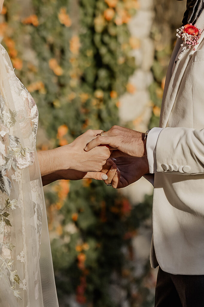 Close up shot of a bride and groom holding hands during their ceremony. 