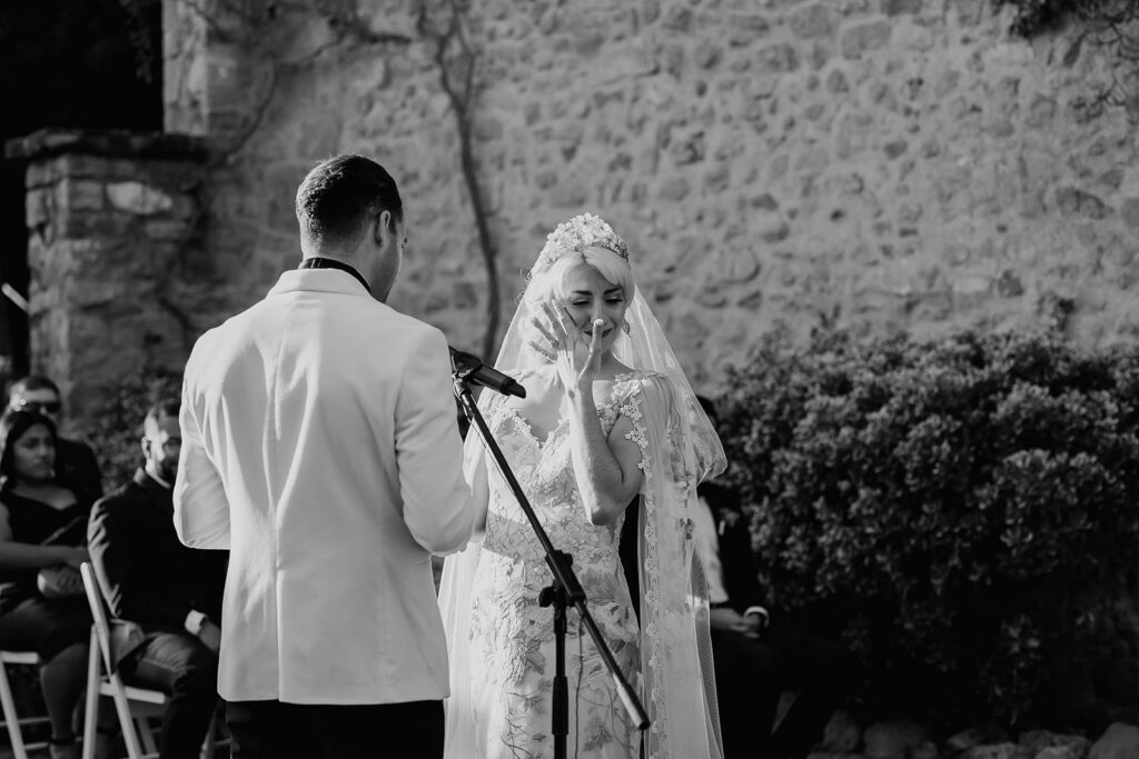 Black and white photo of the bride getting emotional during vows.