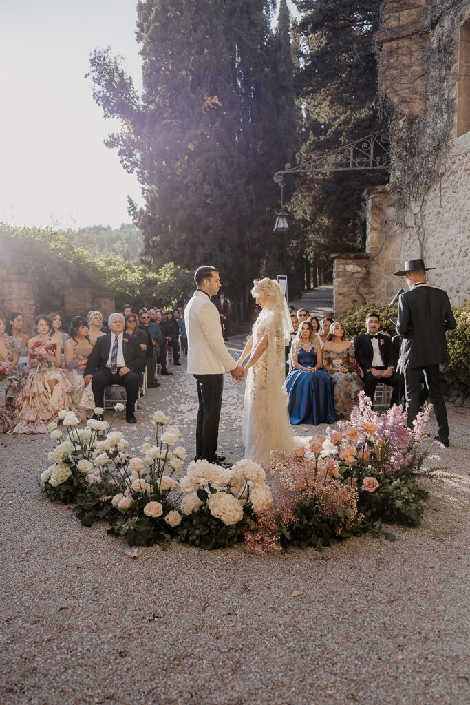 Bride and groom holding hands at the altar during their La Baronia wedding ceremony at the Cabañon in Barcelona Spain.