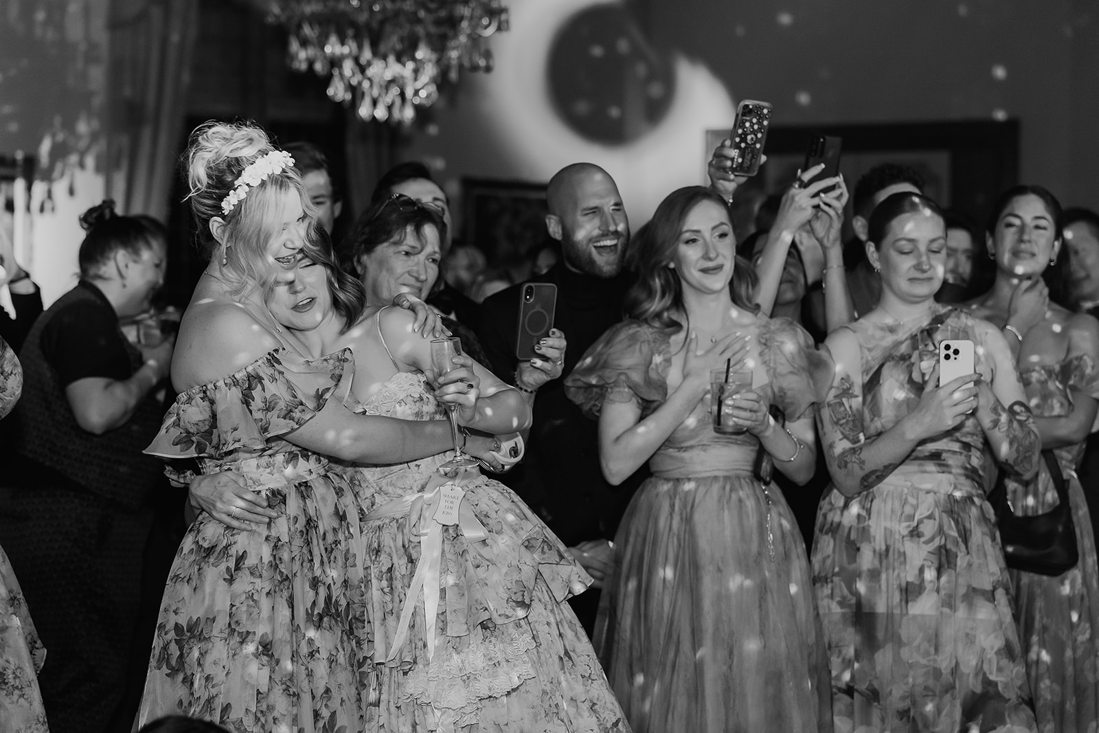 Black and whiter photo of guests watching the bride and grooms first dance.