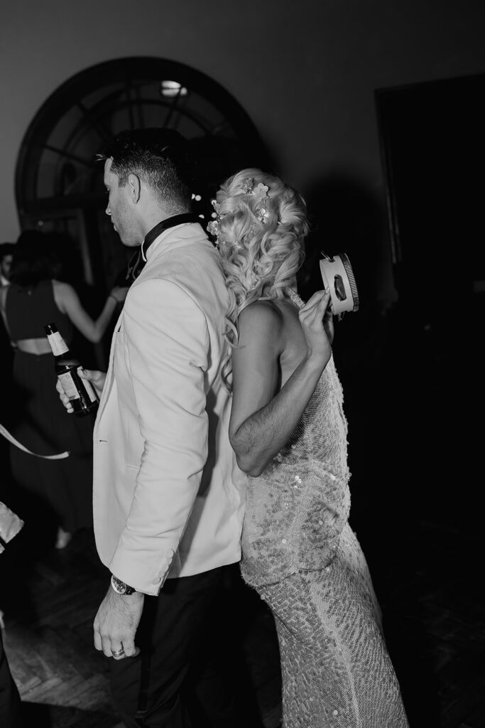 Black and white photo of a bride and groom dancing during the reception. 