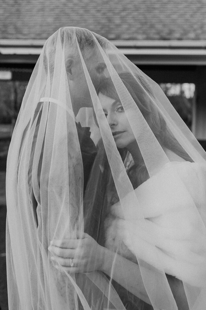 Groom kissing the bride under her veil.