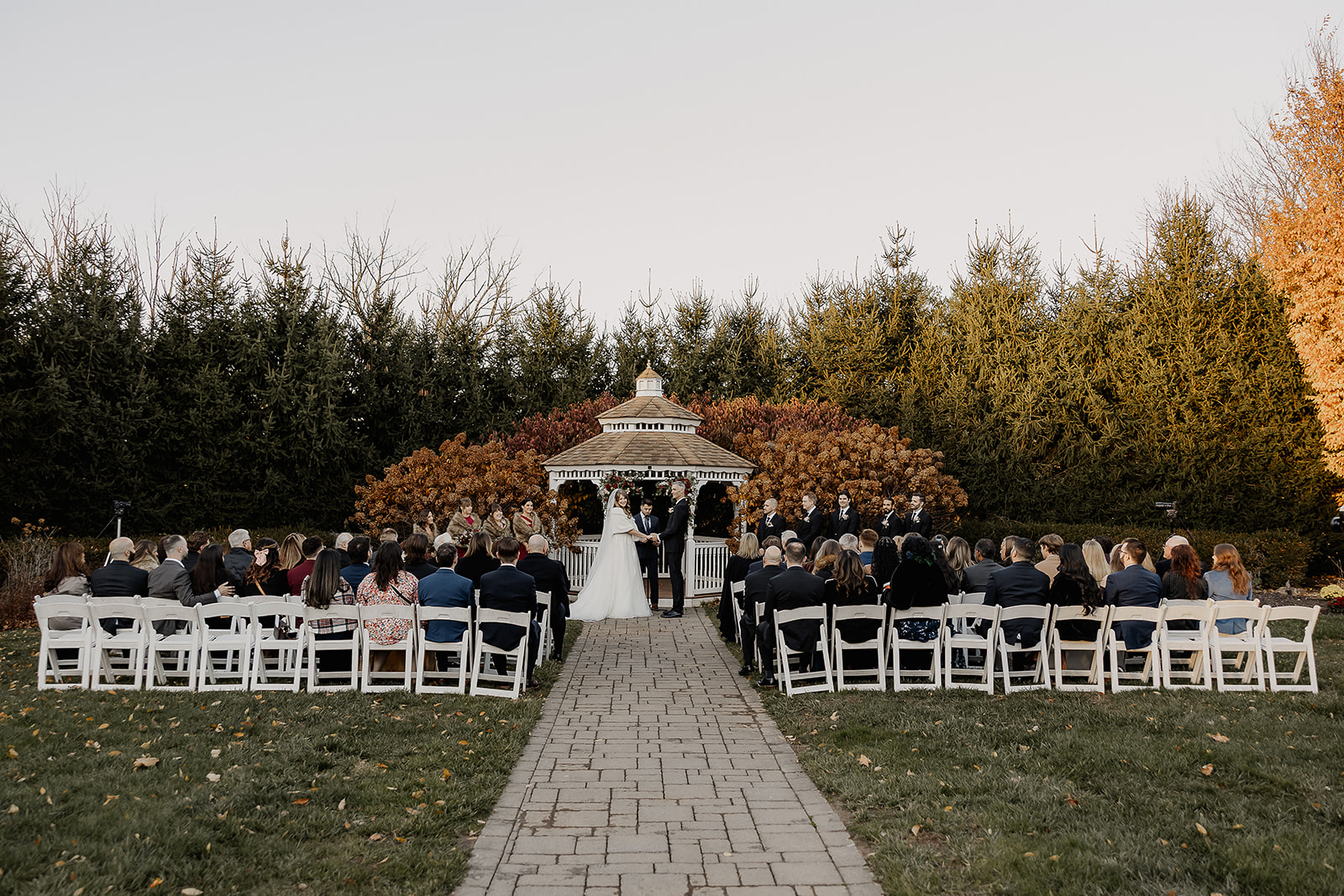 Wide view of outdoor gazebo ceremony with guests seated at The Farmhouse wedding venue in Hampton, NJ.