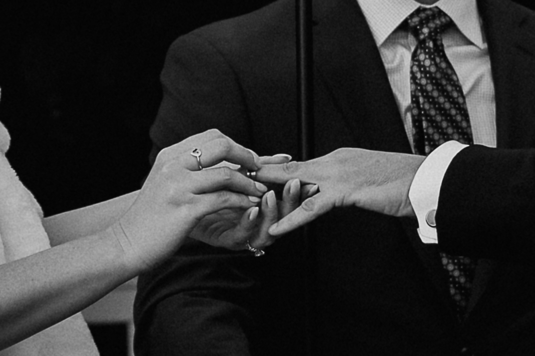 Close up of bride placing ring on groom’s finger during ceremony at The Farmhouse wedding venue in Hampton, NJ.