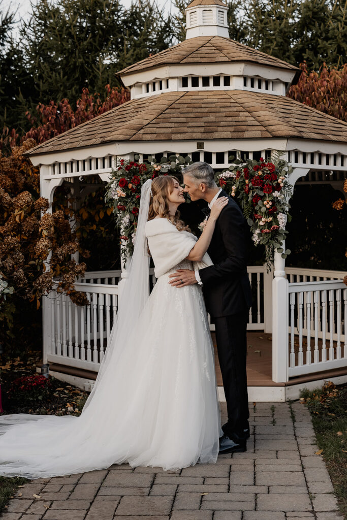 Bride and groom kissing at end of ceremony at gazebo at The Farmhouse wedding venue in Hampton, NJ.