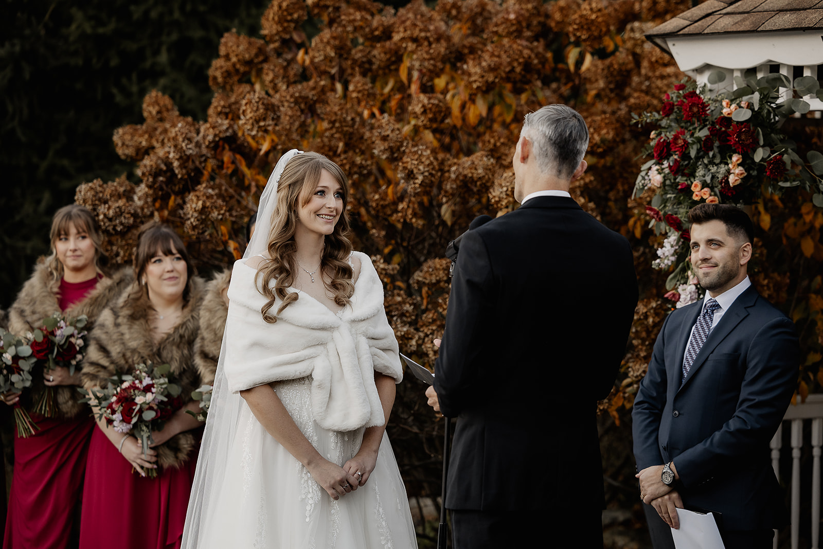 Bride smiling during ceremony while facing groom at The Farmhouse wedding venue in Hampton, NJ.