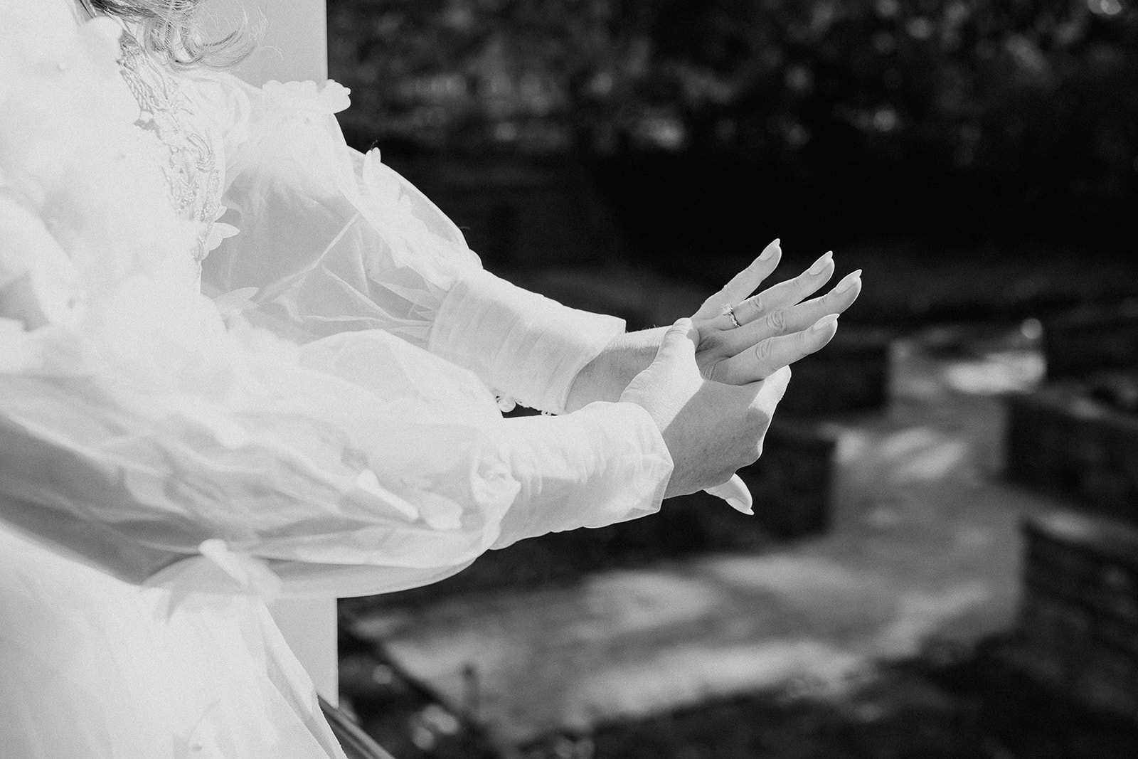 Black and white photo of a bride admiring her wedding ring.