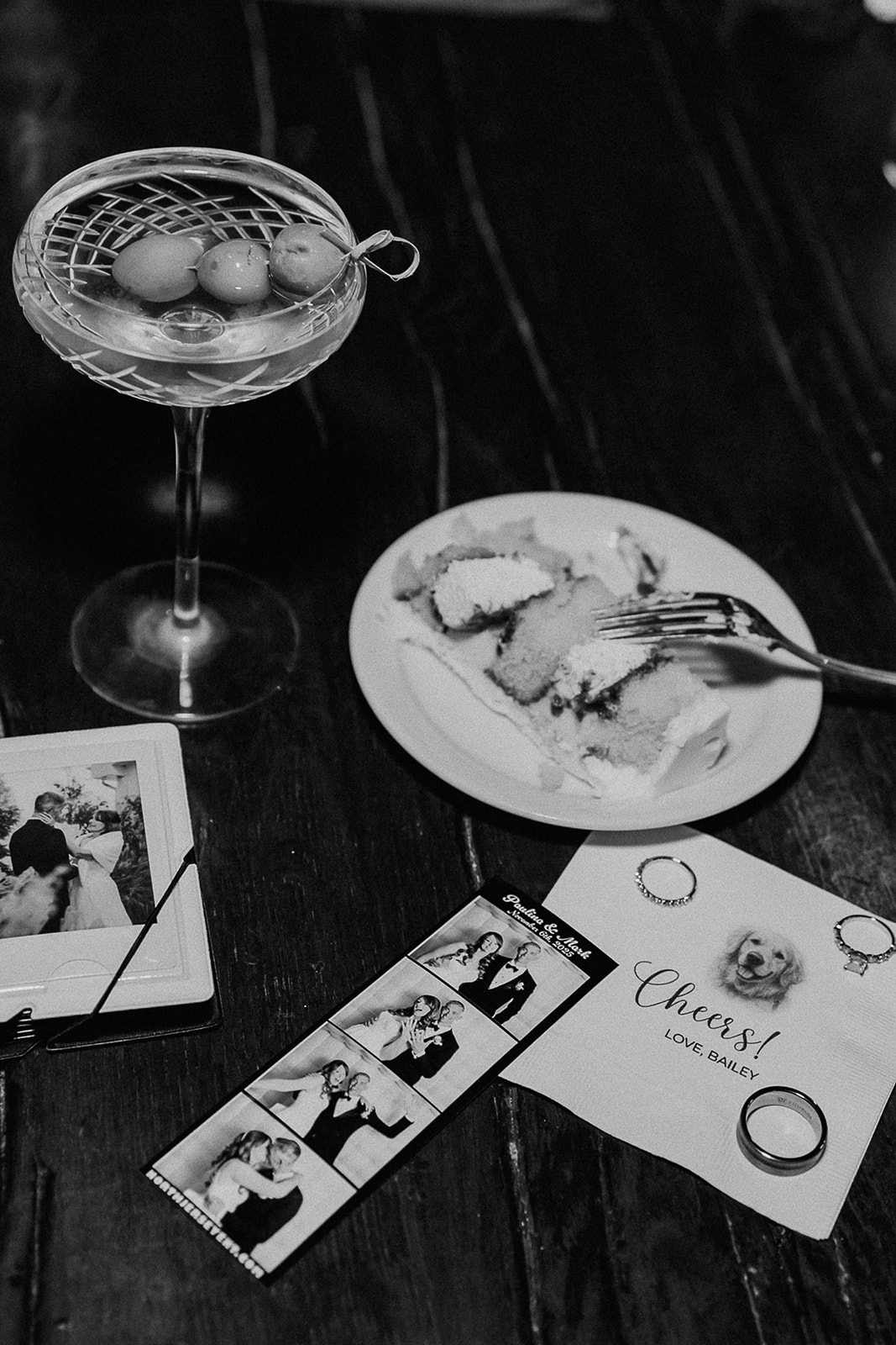 Flat lay of wedding reception details including rings, photo strip, and dog napkin at The Farmhouse wedding venue in Hampton, NJ.