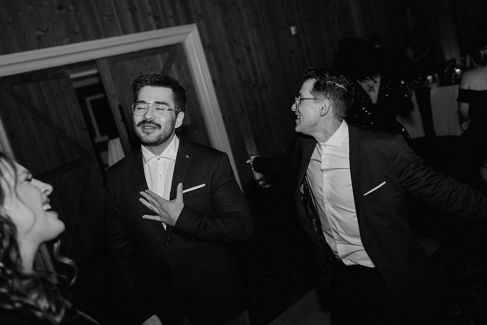 Black and white photo of guests dancing during the reception.