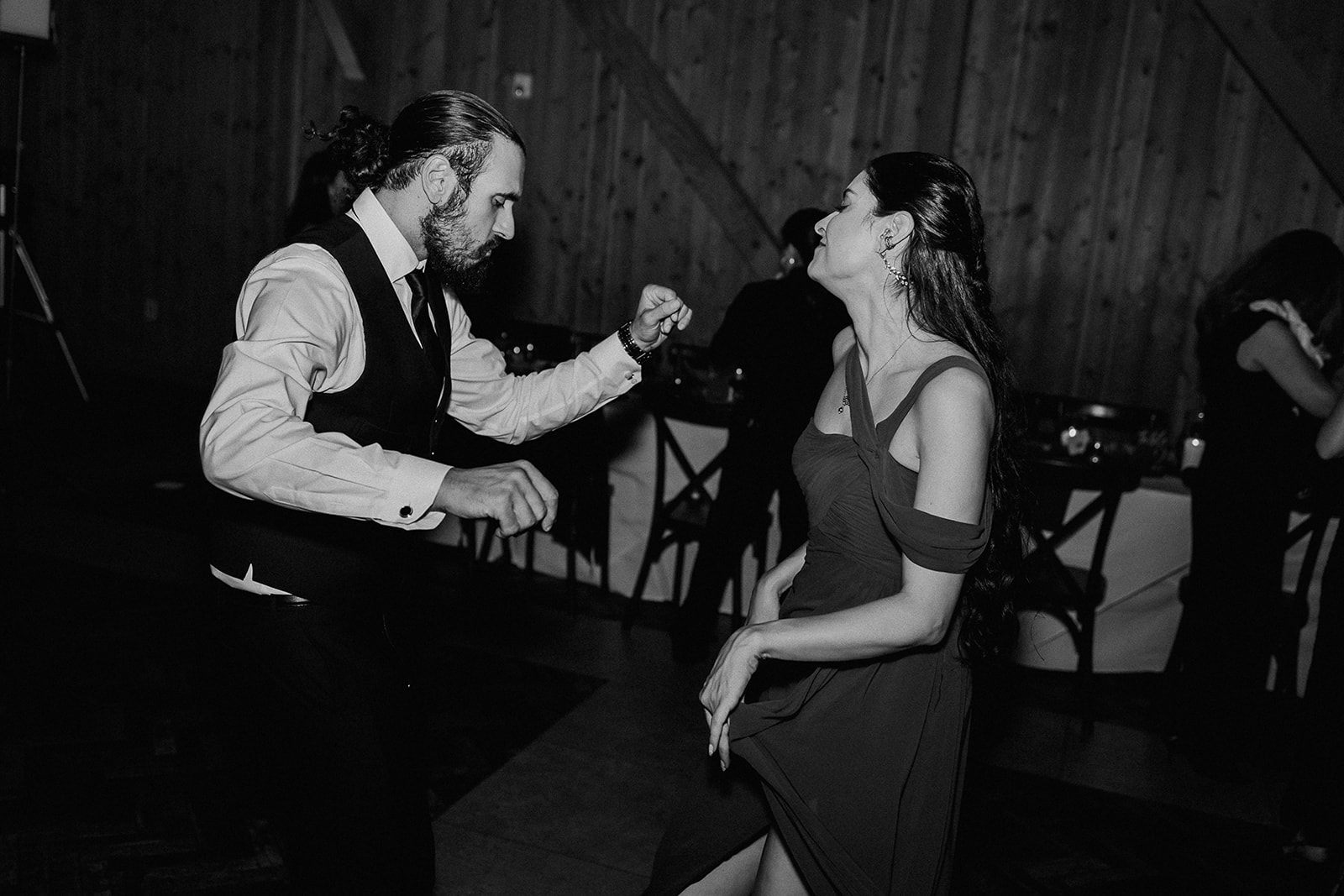 Black and white photo of guests dancing during the reception.
