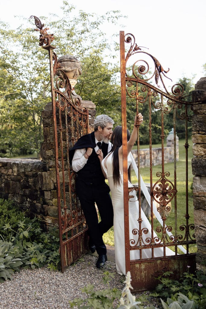 Couple kissing by a gate at Jardin de Buis in New Jersey.