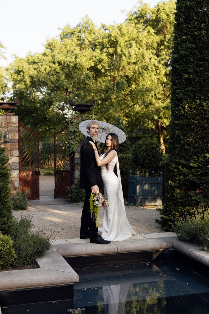 Couple posing in front of a pool at Jardin de Buis in New Jersey.