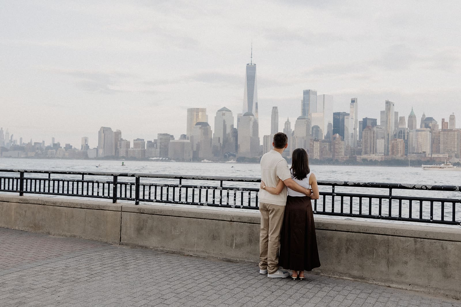 Couple admiring the views of NYC from Liberty State Park in Jersey City, NJ for their engagement session.