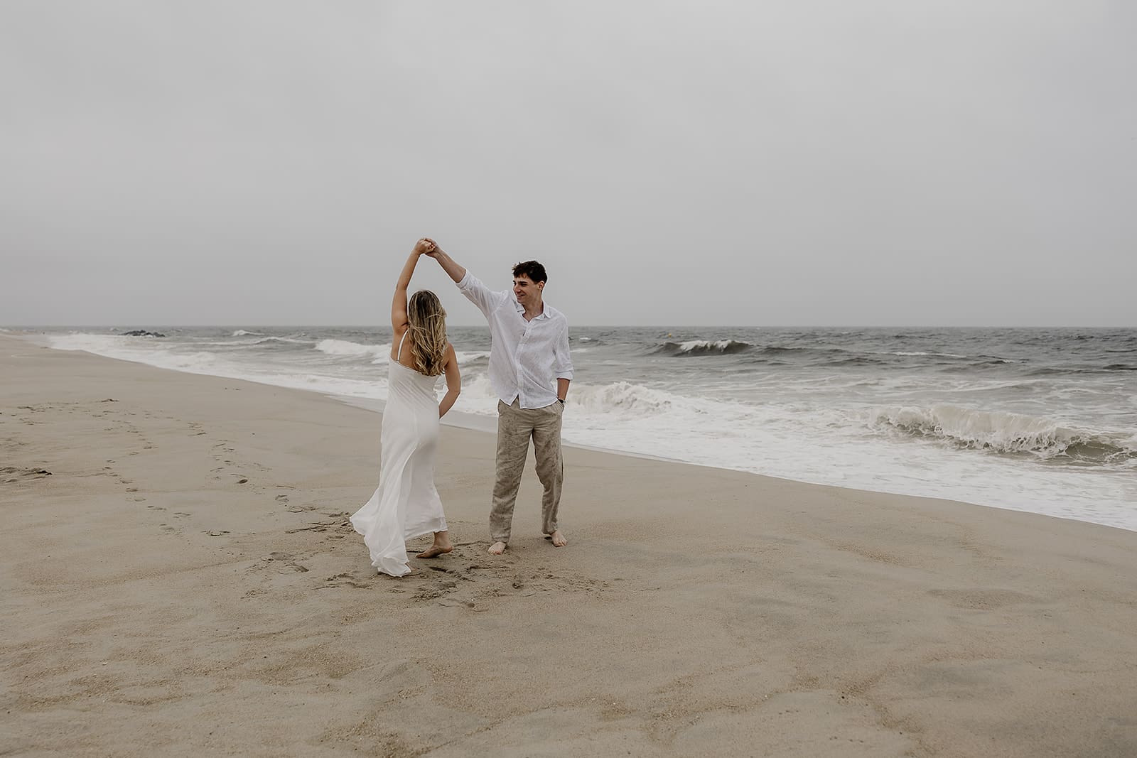 Couple dancing on the beach for their Long Branch Beach engagement photos in NJ.