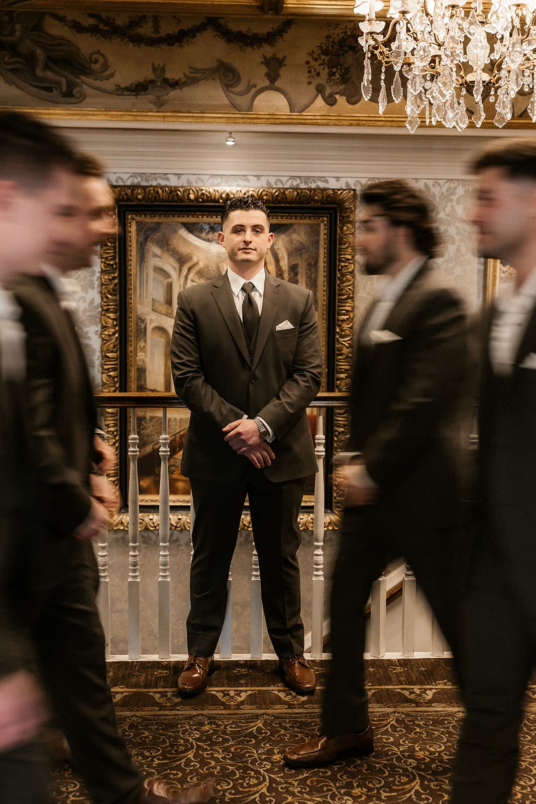 Motion blur photo of a groom posing with groomsmen inside The Brownstone in Paterson, NJ.


