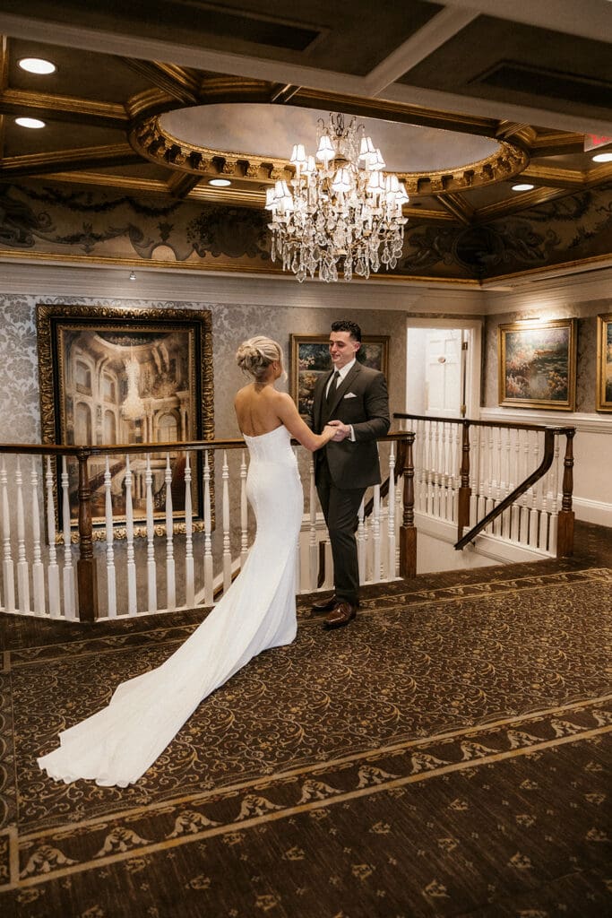 Bride and groom holding hands after sharing their first look at The Brownstone in Paterson, NJ.