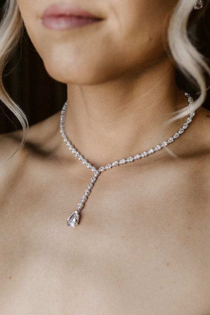 Close up shot of a bride wearing her necklace. 