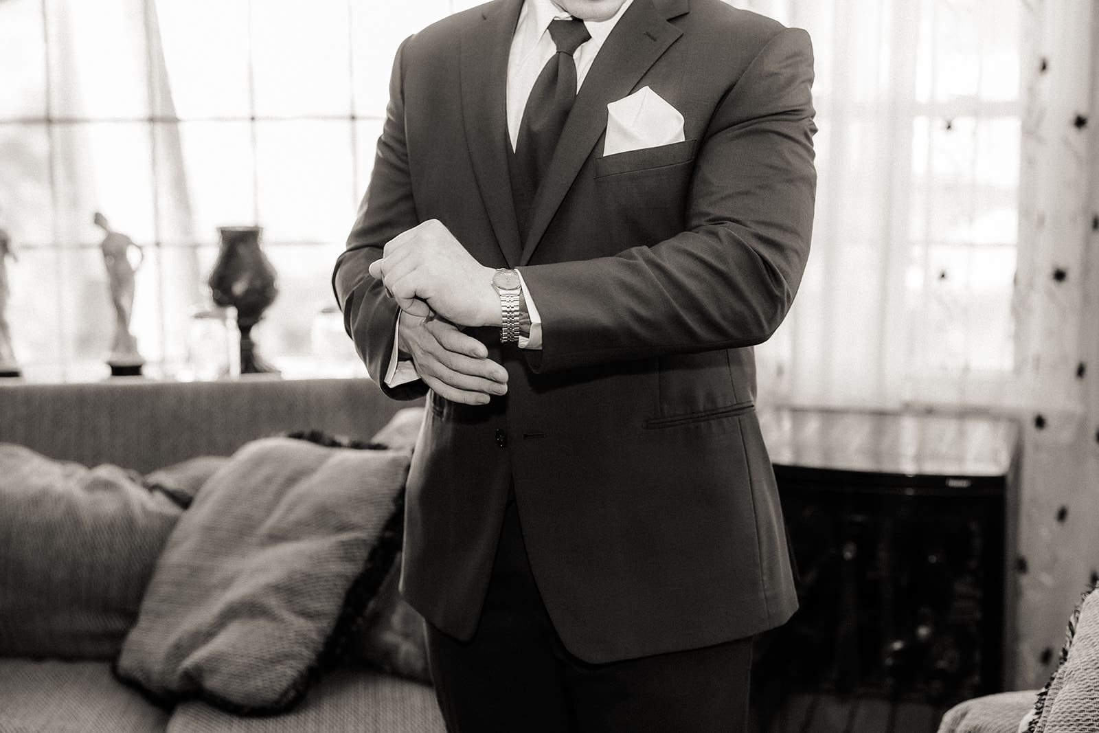 Black and white close up shot of a groom getting ready.