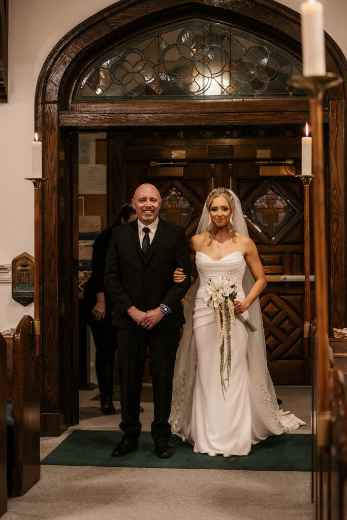 Bride walking down the aisle with her father during a Catholic wedding ceremony at St. Mary’s Church in Pompton Lakes, NJ.