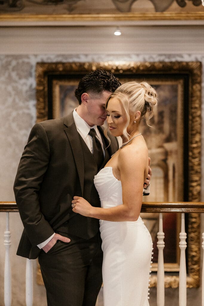 Bride and groom posing together on the balcony inside The Brownstone in Paterson, NJ.