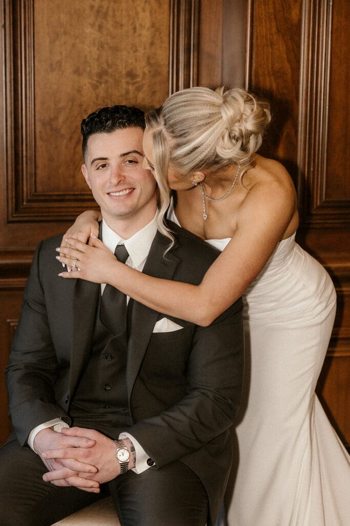 Bride kissing the groom on his cheek.