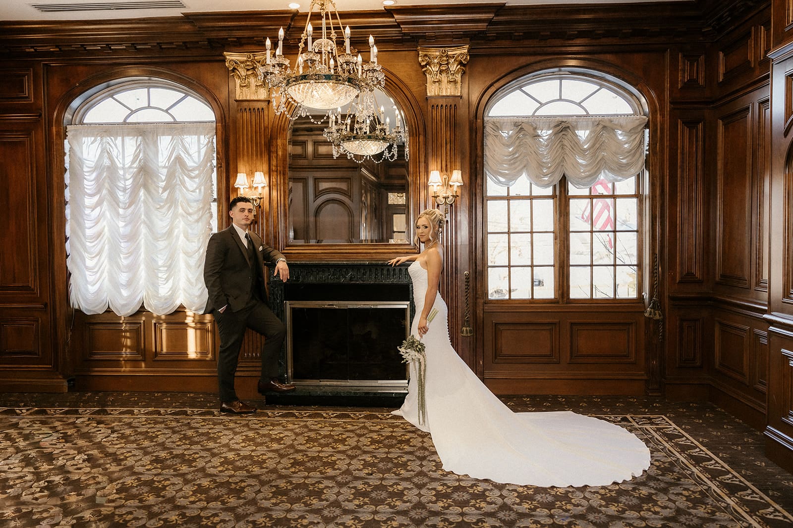 Bride and groom posing by the fireplace inside The Brownstone in Paterson, NJ.