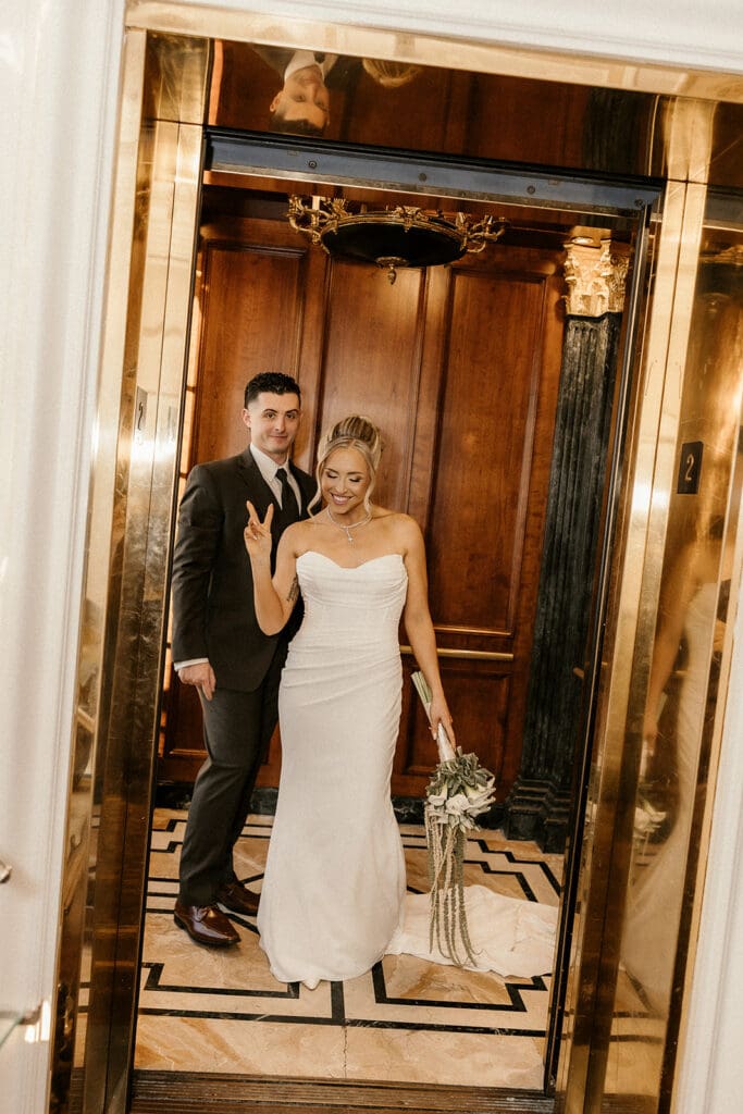 Bride and groom smiling inside the gold elevator at The Brownstone in Paterson, NJ.