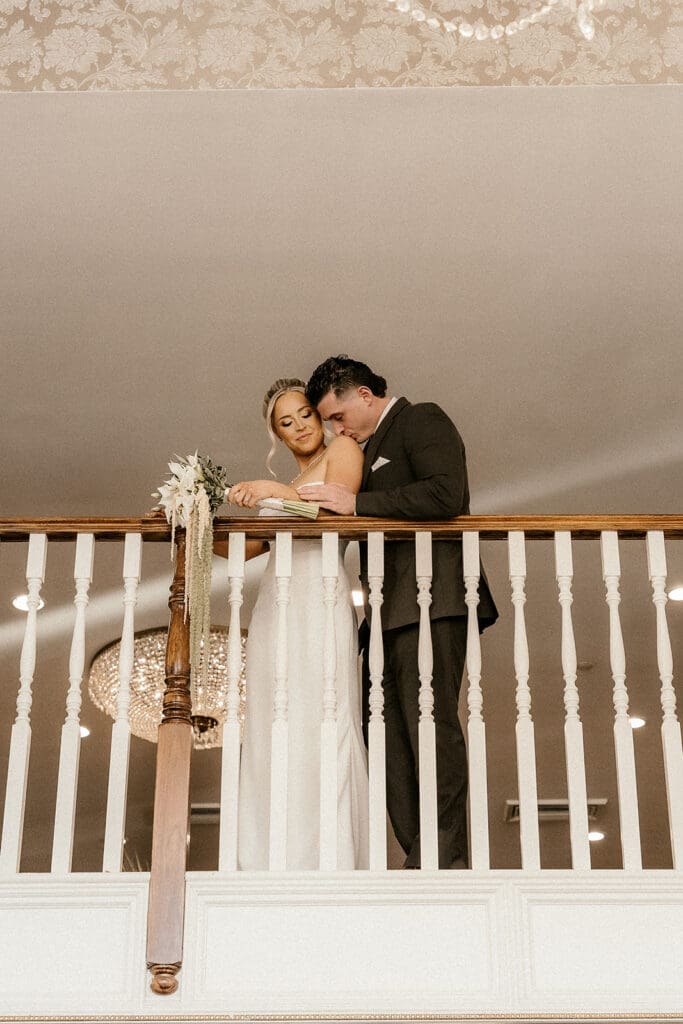 Bride and groom posing together on the balcony inside The Brownstone in Paterson, NJ.