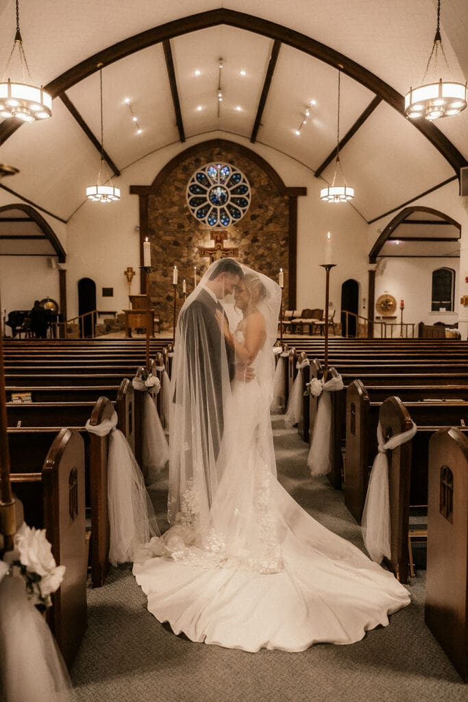 Bride and groom posing in the aisle after their ceremony at St. Mary’s Church in Pompton Lakes, NJ.