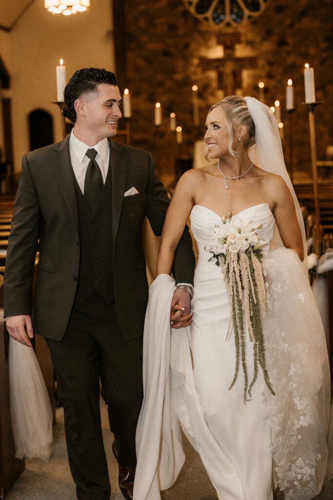 Bride and groom walking back down the aisle after a ceremony at St. Mary’s Church in Pompton Lakes, NJ.
