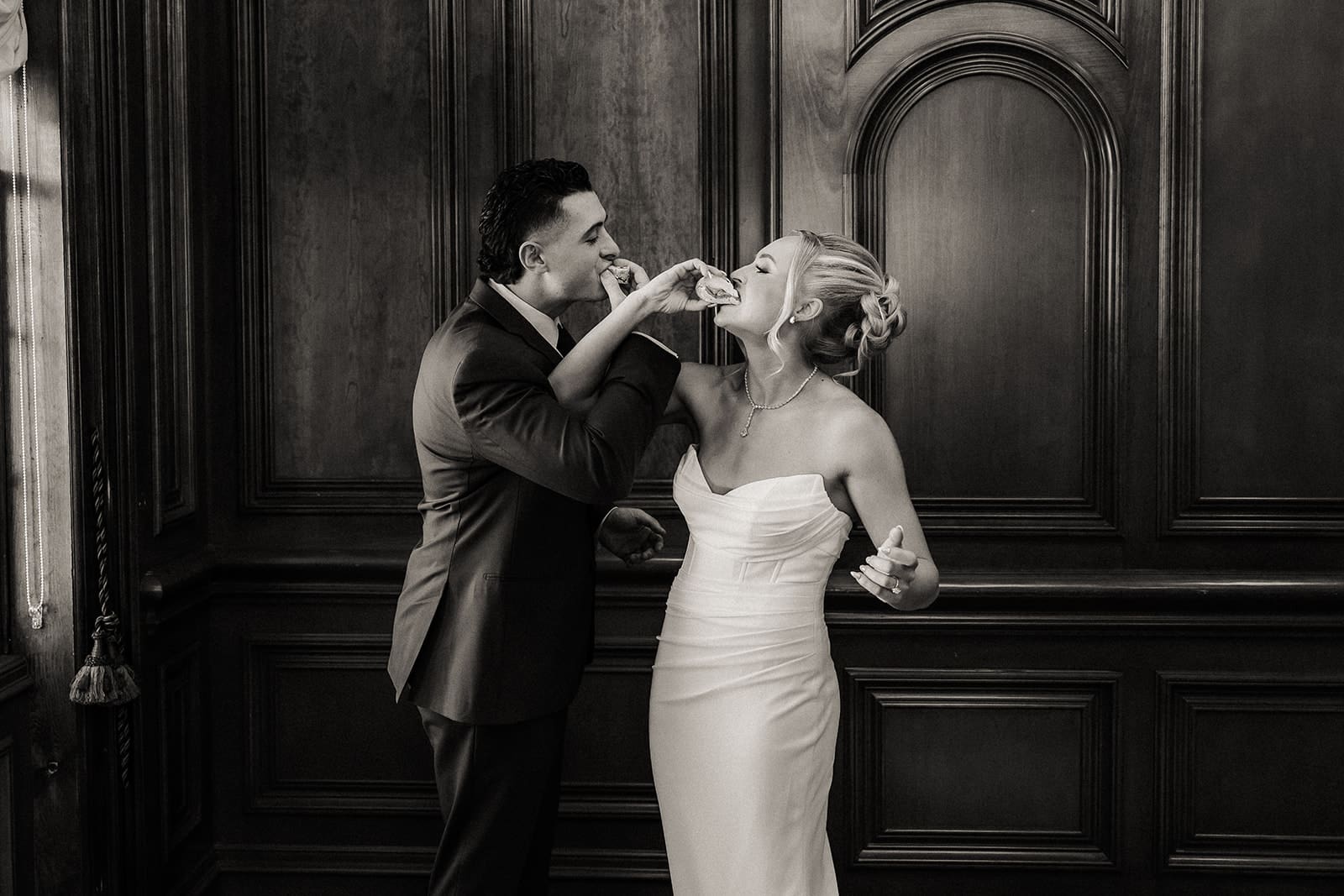 Black and white photo of the bride and groom taking a shot together before the ceremony.
