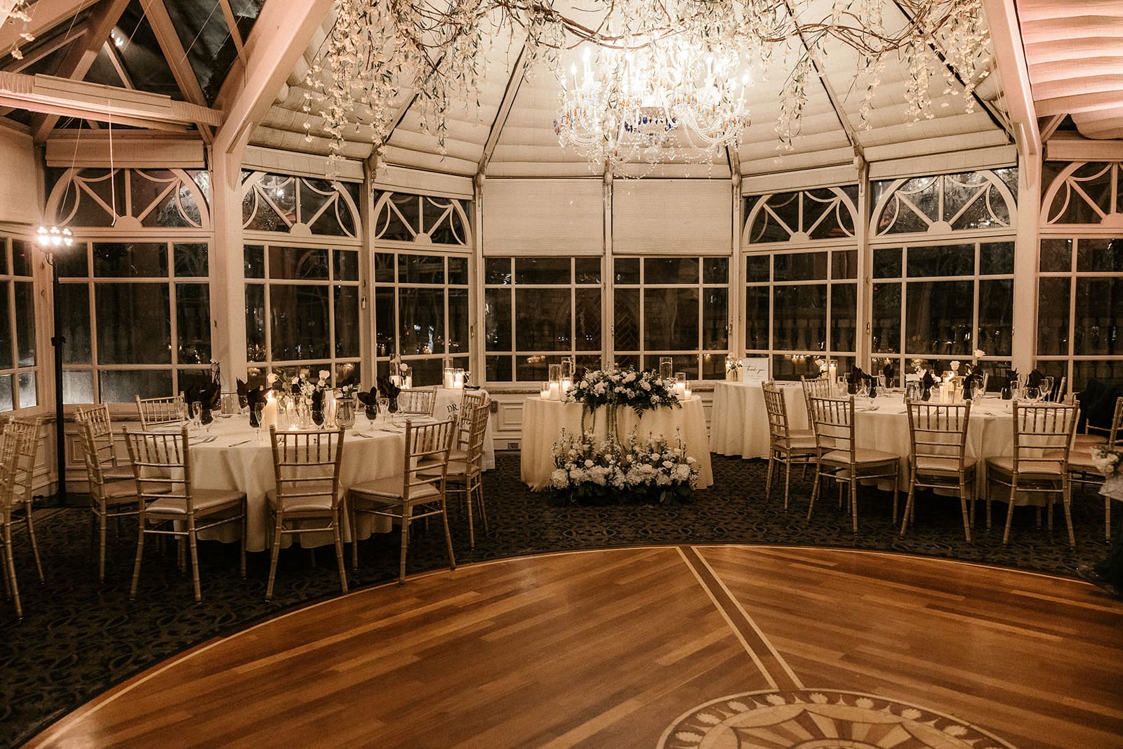 Wedding reception space with candlelit tables and white florals at The Brownstone in Paterson, NJ.