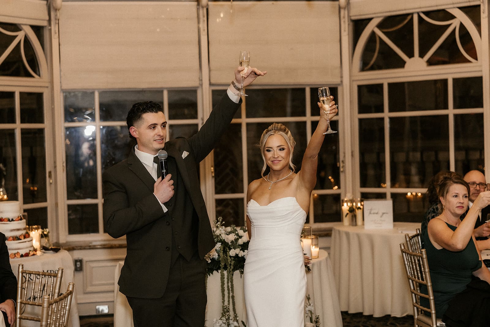 Bride and groom toasting with champagne during speeches.