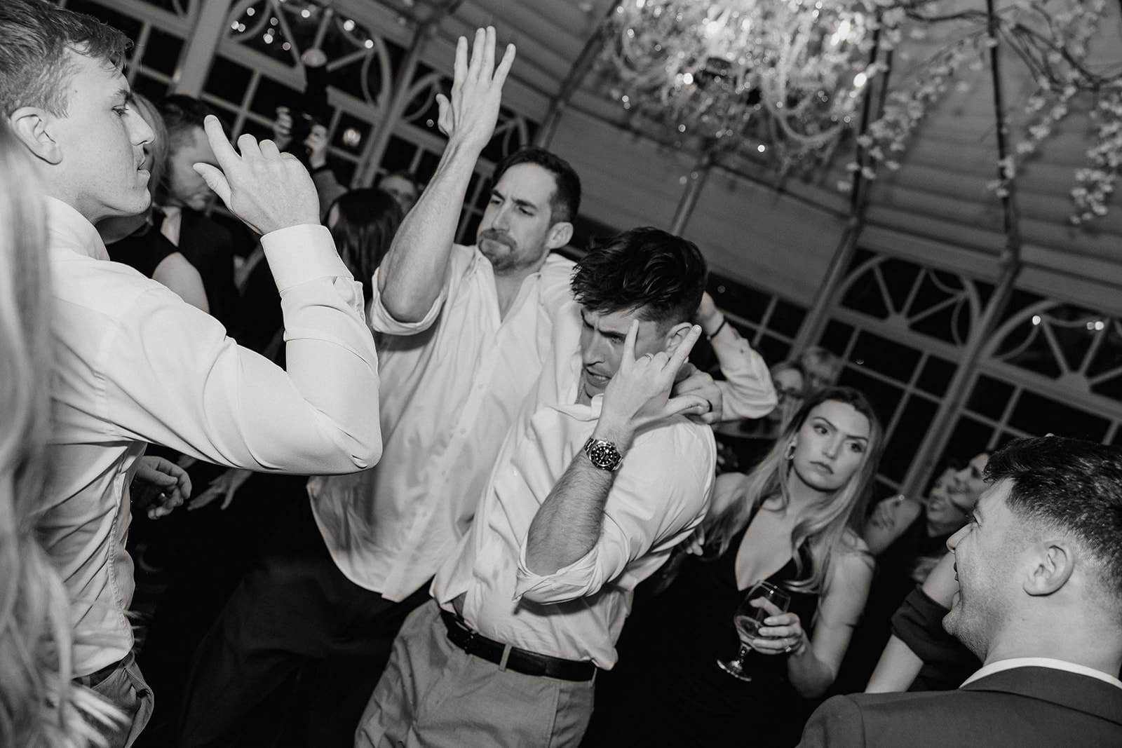 Black and white photo of guests dancing during the reception.