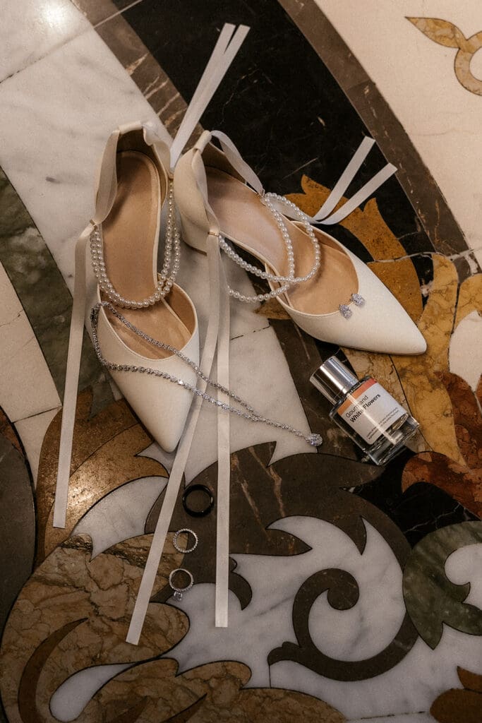 Brides heels, jewelry, rings, and perfume style for a flat lay shot.
