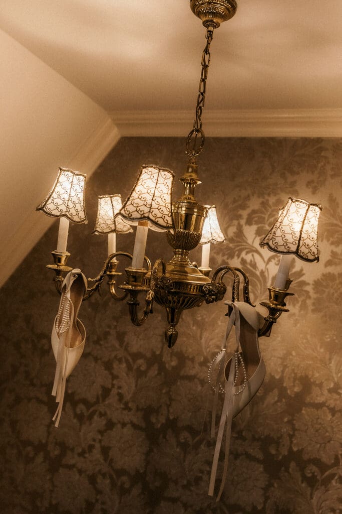 Brides heels hanging from a chandelier at Brides dress hanging on the wall at The Brownstone in Paterson, NJ.
