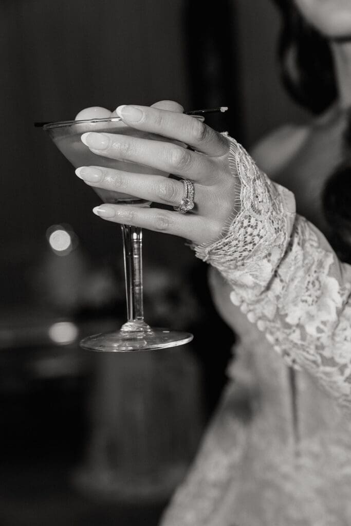 Close up editorial shot of a bride holding her cocktail.