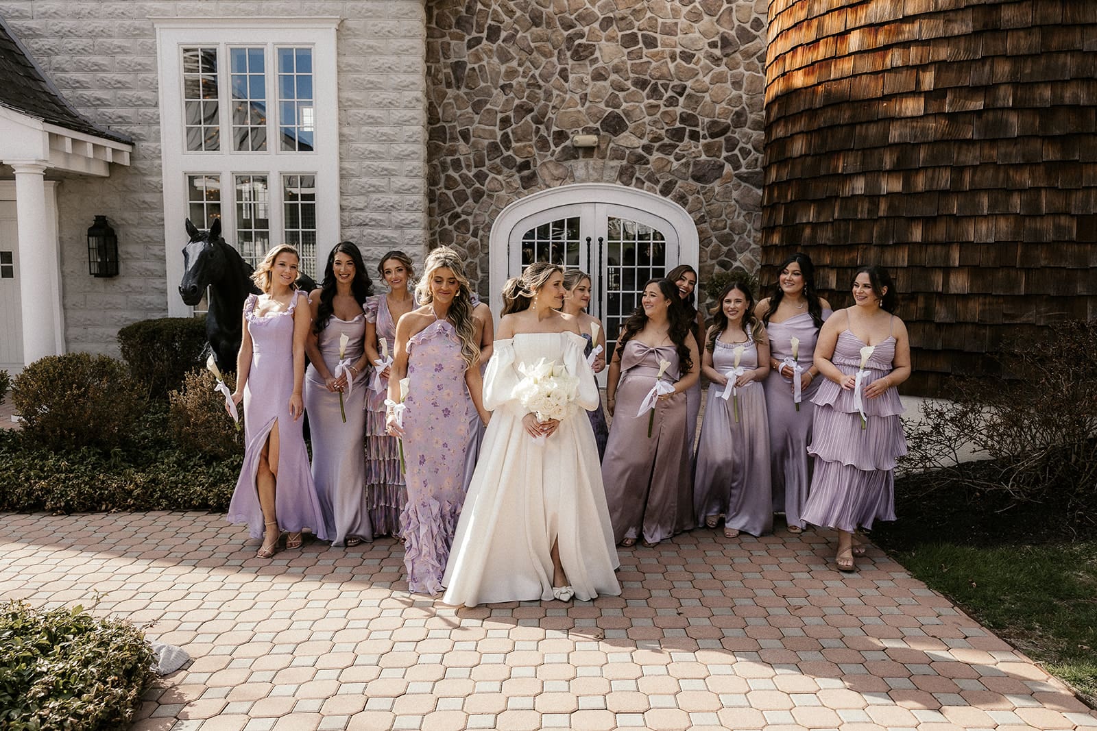 Bride with bridesmaids in mismatched purple dresses at The Ryland Inn wedding venue.
