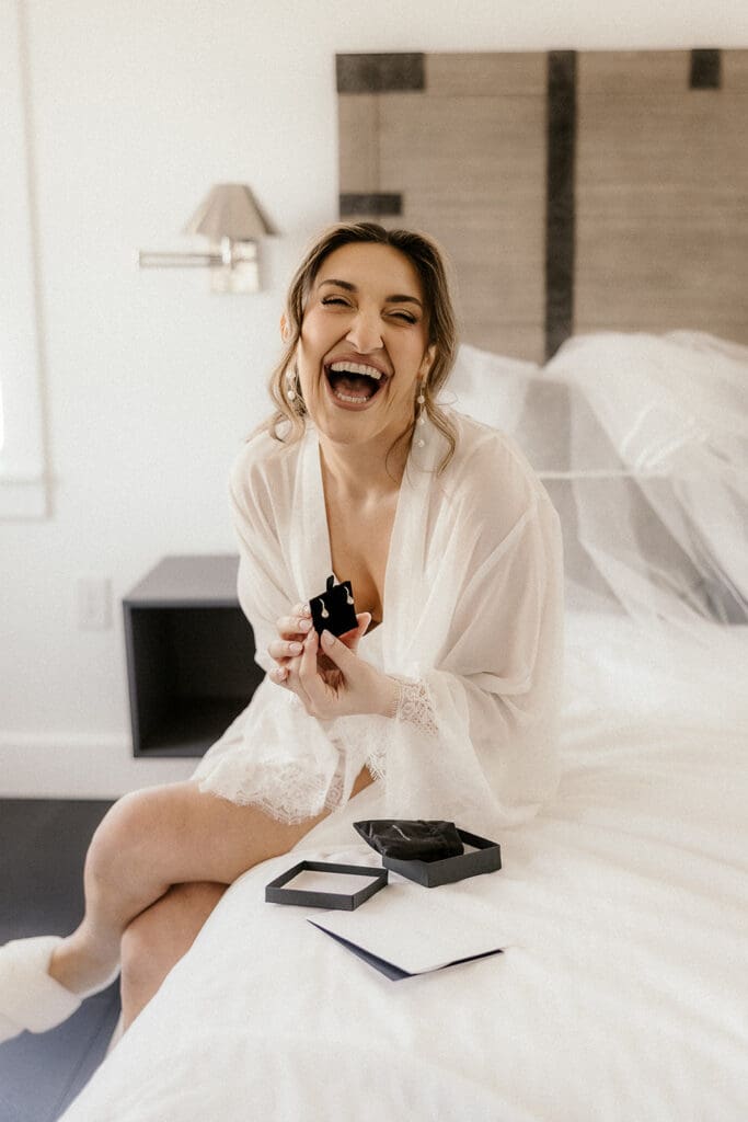 Bride laughing as she opens a gift.