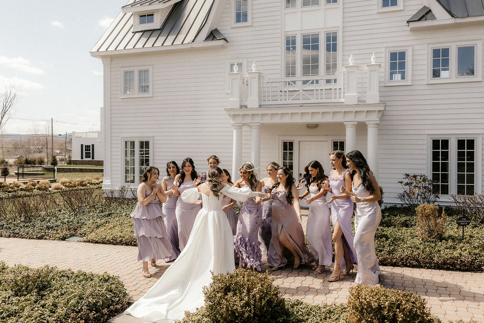 Bride sharing a first look with her bridesmaids outside of the suite at The Ryland Inn.