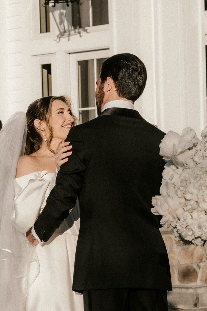 Bride smiling at the groom during their outdoor ceremony at The Ryland Inn.
