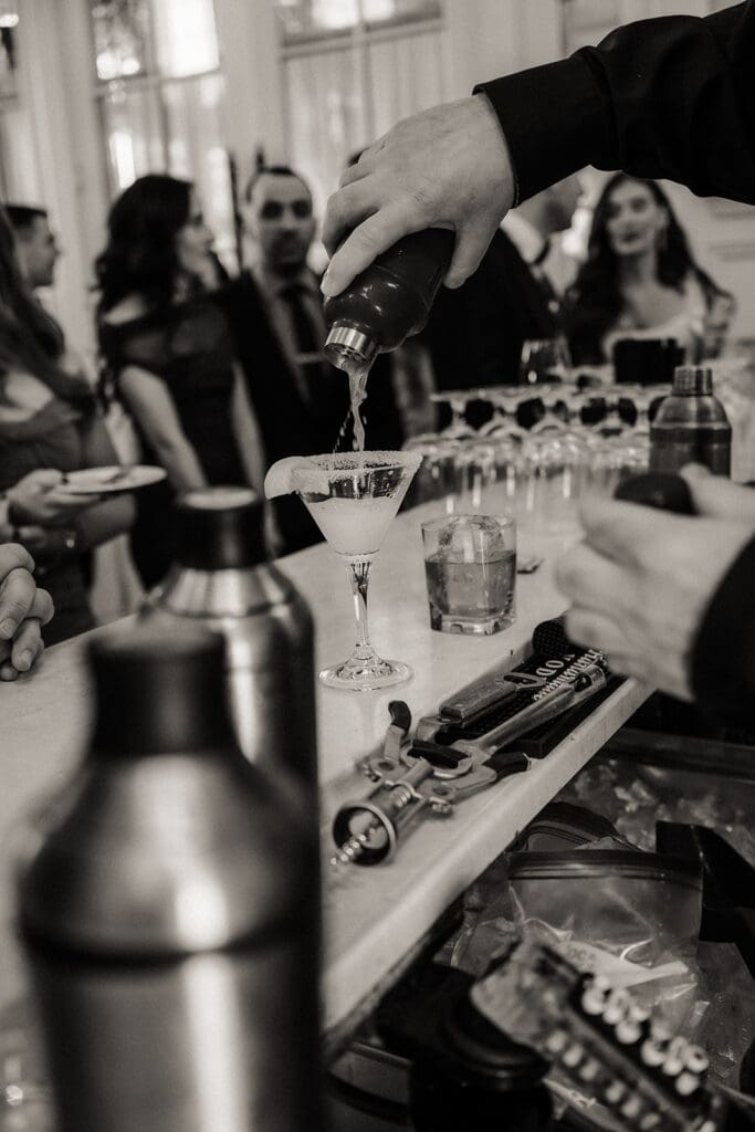 Black and white photo of drink being poured during cocktail hour.