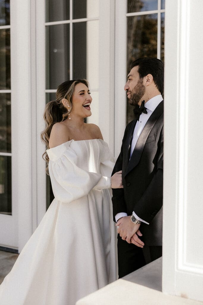 Bride and groom laughing together during portraits outside The Ryland Inn wedding venue in White House Station, NJ.
