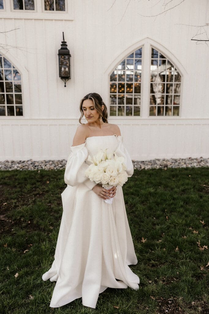 Bride holding a white rose wedding bouquet outside of The Ryland Inn wedding venue in White House Station, NJ.