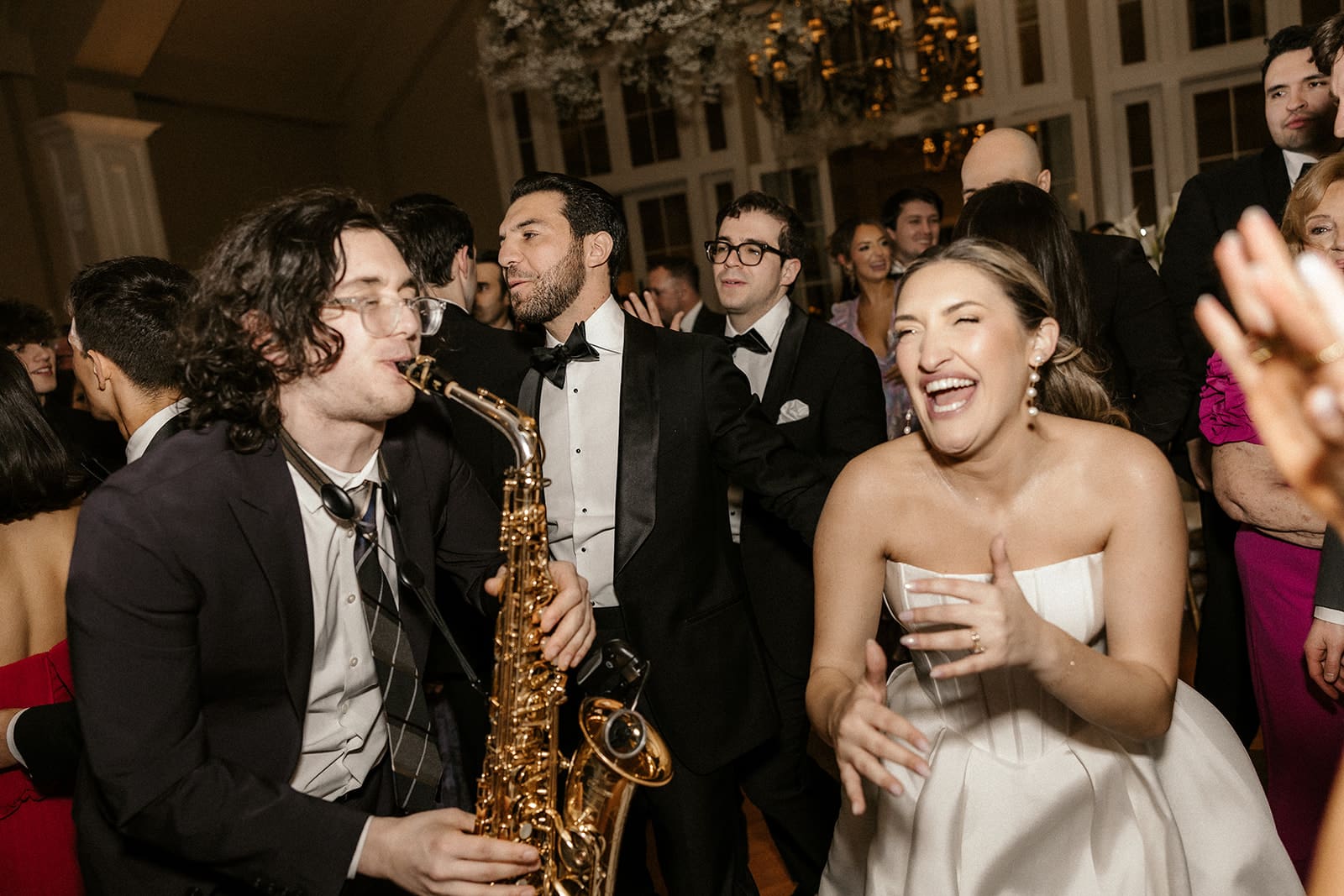 Bride laughing near the saxophone player during her The Ryland Inn wedding reception.