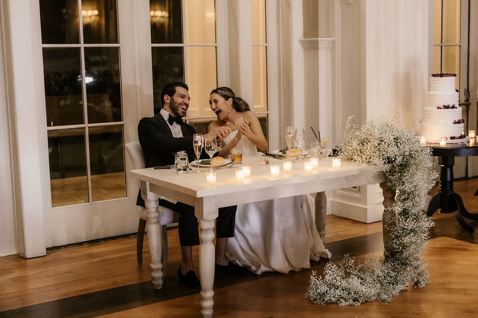 Bride and groom laughing during speeches.