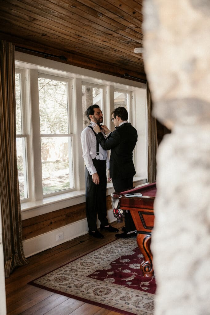 Groomsmen helping the groom get ready.