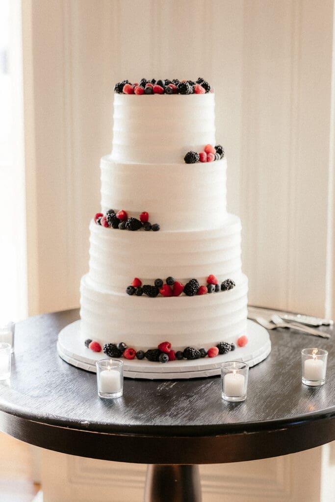 White wedding cake with berries at The Ryland Inn wedding reception.